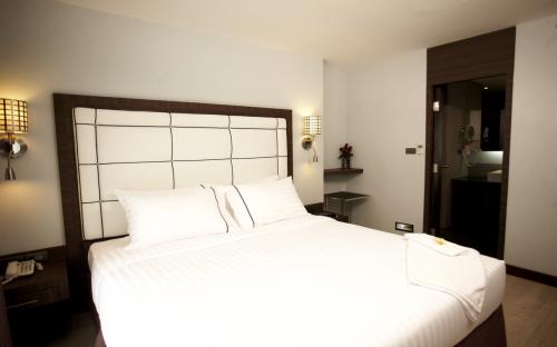 Sukhumvit Suites Bangkok - Suite room with bathroom towels, bathrobe, and slippers